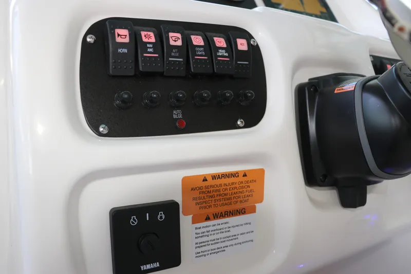 Slide: The Image of Control panel of 2026 Robalo R207 Dual Console boat with switches and warning labels. - 19