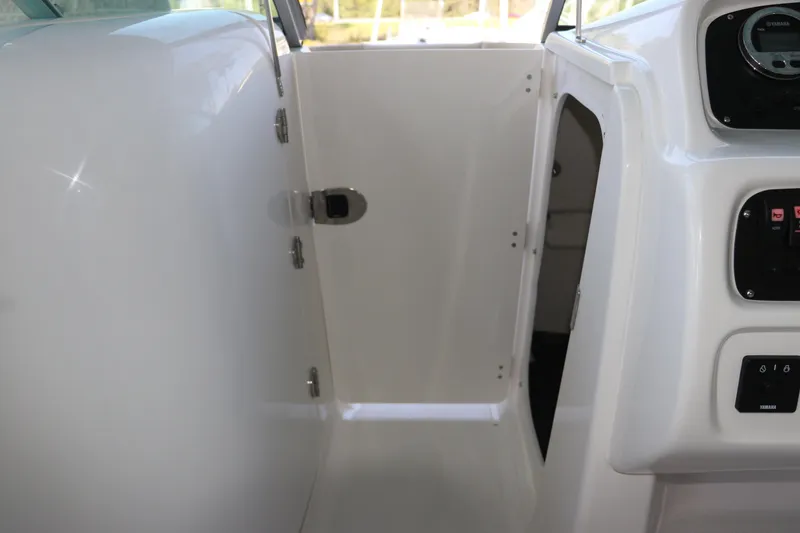 Slide: The Image of 2026 Robalo R207 Dual Console interior with open storage compartment and control panel. - 23