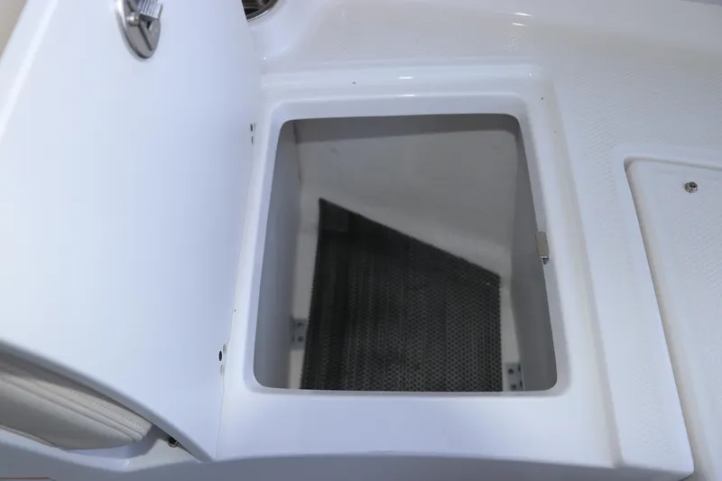 Slide: The Image of Open storage compartment on 2026 Robalo R207 Dual Console boat. - 26