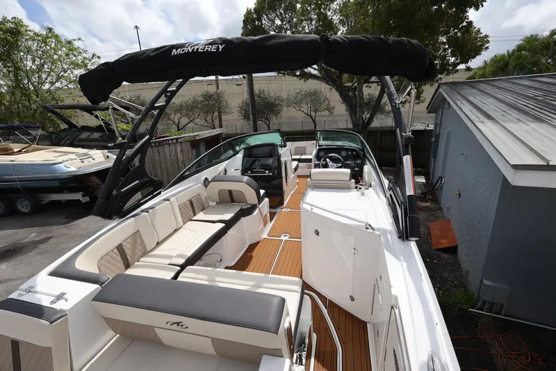 Slide: The Image of 2021 Monterey M-65 boat with spacious seating and sleek design in a yard setting. - 10