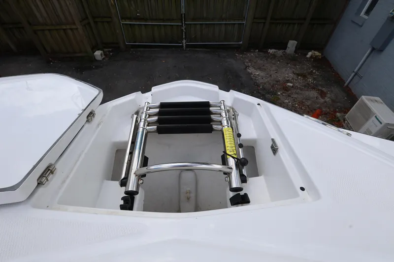 Slide: The Image of 2021 Monterey M-65 boat ladder compartment, featuring a stainless steel retractable ladder. - 17