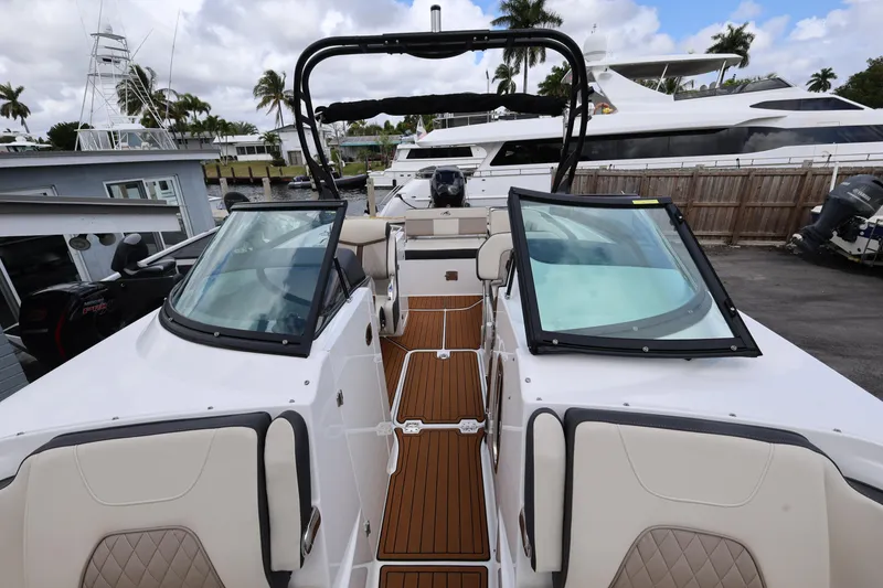 Slide: The Image of 2021 Monterey M-65 boat interior with open deck and seating, docked near yachts. - 20