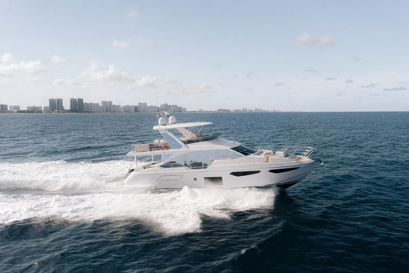 Slide: The Image of Luxury 2020 Azimut 60 yacht cruising on open sea near city skyline. - 39