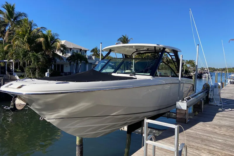 The Image of 2024 Boston Whaler 320 Vantage boat docked by a scenic waterfront. - 0