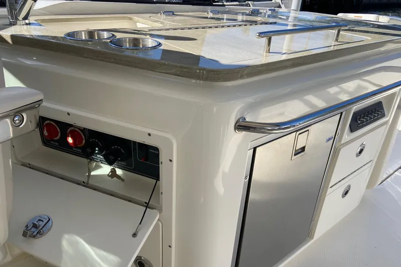 Slide: The Image of 2024 Boston Whaler 320 Vantage boat interior with control panel and storage compartments. - 11