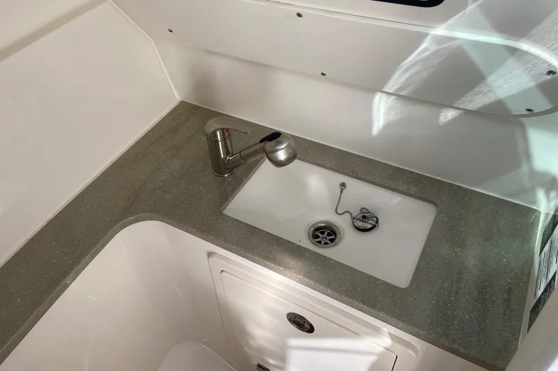 Slide: The Image of 2024 Boston Whaler 320 Vantage interior sink with modern faucet and countertop. - 15