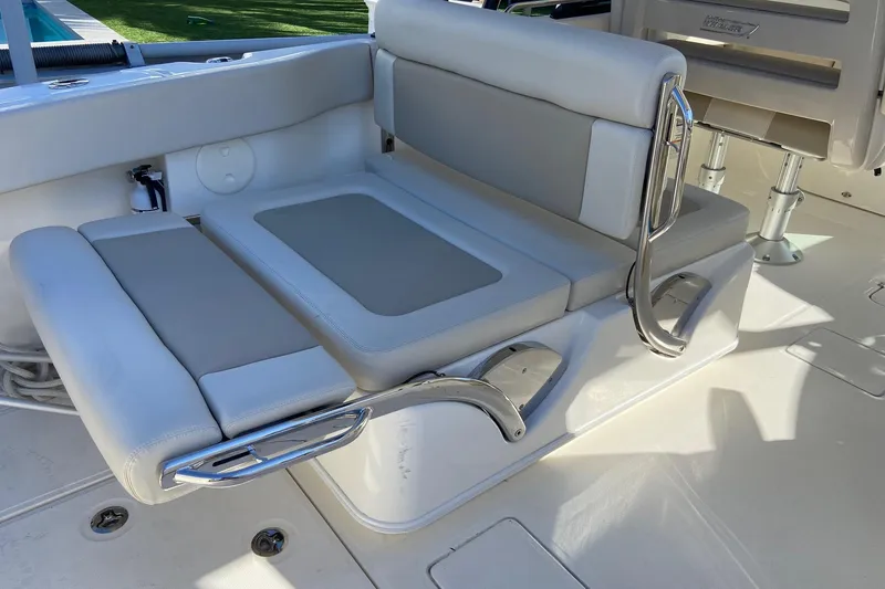 Slide: The Image of 2024 Boston Whaler 320 Vantage boat seating area with cushioned seats and stainless steel handles. - 20