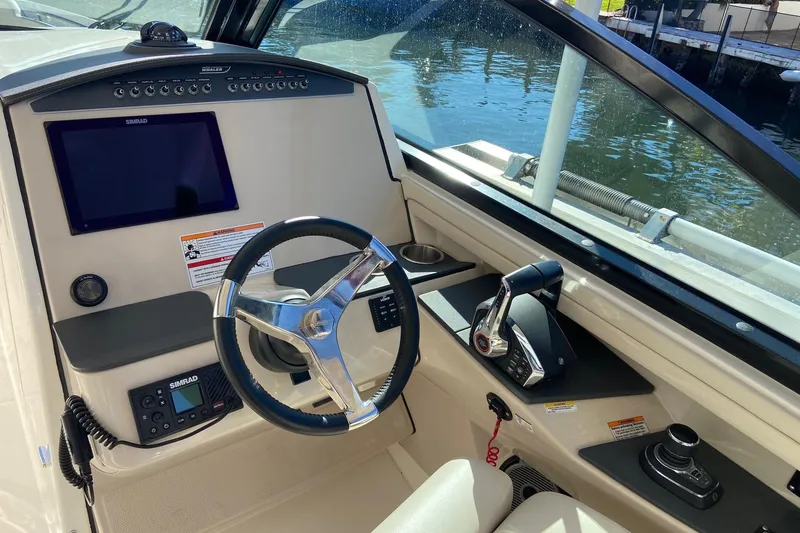 Slide: The Image of 2024 Boston Whaler 320 Vantage helm with steering wheel, controls, and Simrad display. - 26