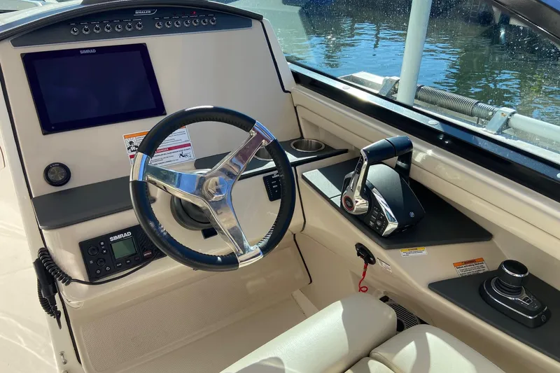 Slide: The Image of 2024 Boston Whaler 320 Vantage helm with steering wheel and control panel. - 27