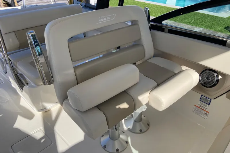 Slide: The Image of 2024 Boston Whaler 320 Vantage boat interior with beige seating and chrome accents. - 28