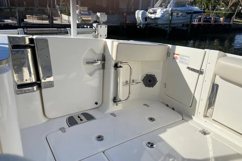Slide: The Image of 2024 Boston Whaler 320 Vantage boat interior with open hatch and dock view. - 4
