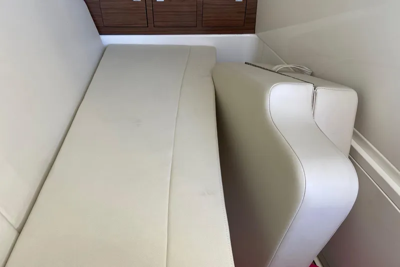 Slide: The Image of 2024 Boston Whaler 320 Vantage interior seating with beige upholstery and wooden accents. - 40