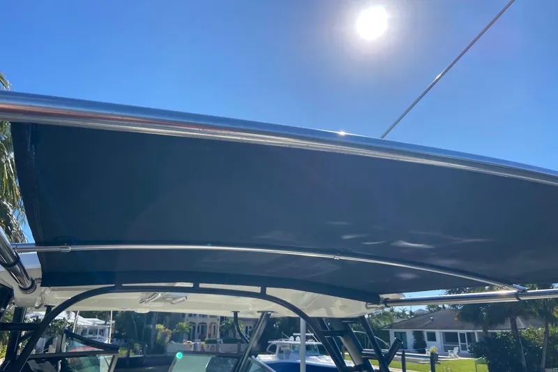 Slide: The Image of 2024 Boston Whaler 320 Vantage boat canopy under sunny sky. - 42
