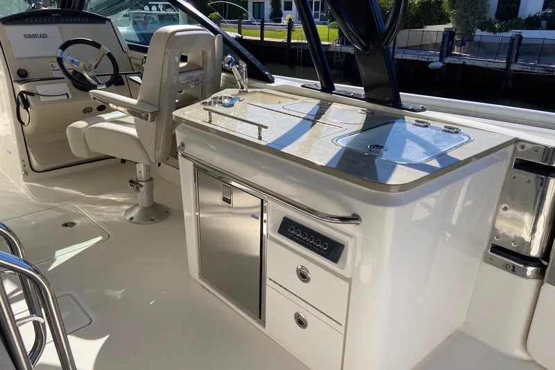 Slide: The Image of 2024 Boston Whaler 320 Vantage interior with helm and kitchenette area. - 46