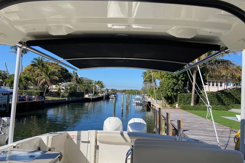 Slide: The Image of 2024 Boston Whaler 320 Vantage docked, view of canal and palm trees. - 47