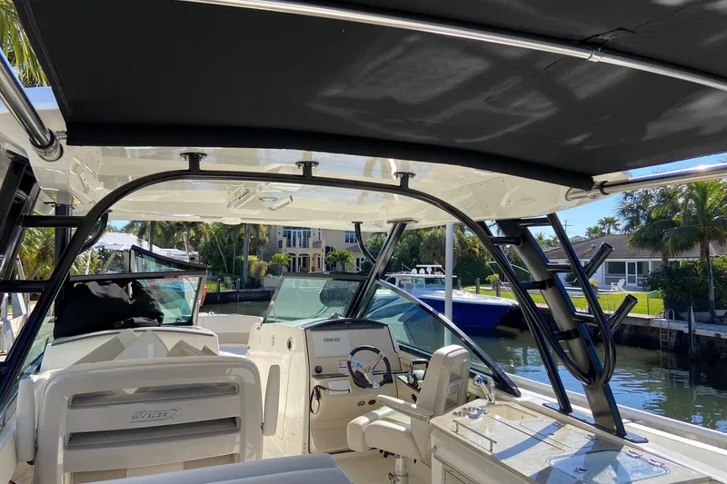 Slide: The Image of 2024 Boston Whaler 320 Vantage boat interior with helm, seats, and canopy. - 48