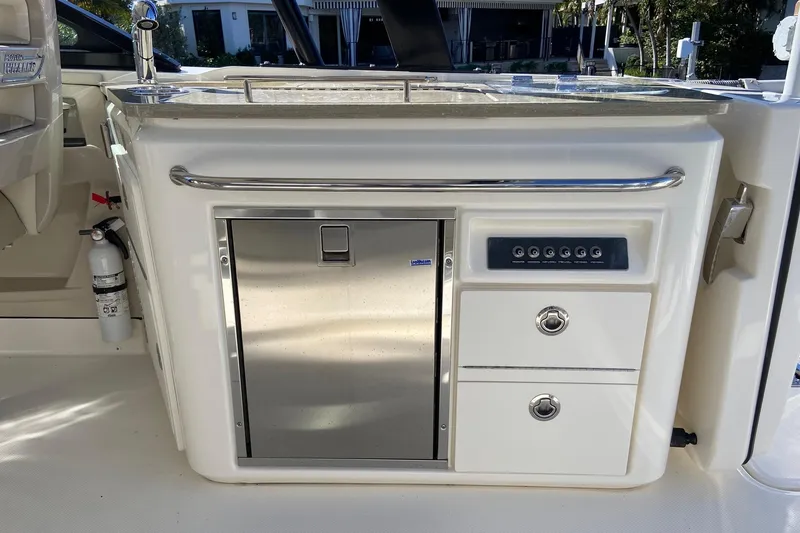 Slide: The Image of 2024 Boston Whaler 320 Vantage boat interior with kitchenette and storage compartments. - 6