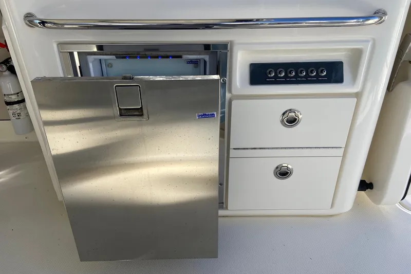 Slide: The Image of 2024 Boston Whaler 320 Vantage boat interior with stainless steel fridge and control panel. - 7