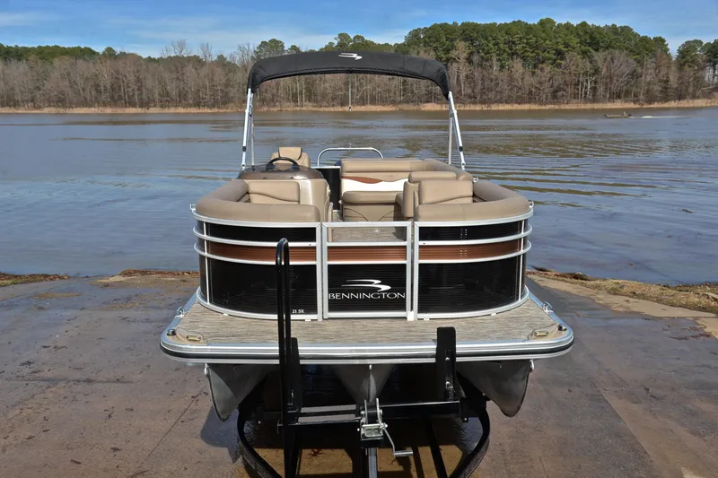 Slide: The Image of 2019 Bennington 21 SSX pontoon boat on a lake with forested background. - 17
