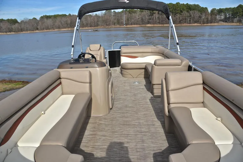 Slide: The Image of 2019 Bennington 21 SSX pontoon boat with spacious seating on a serene lake. - 20