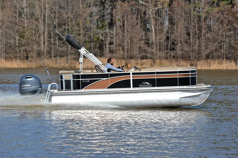 Slide: The Image of 2019 Bennington 21 SSX pontoon boat cruising on a lake with Yamaha engine. - 3