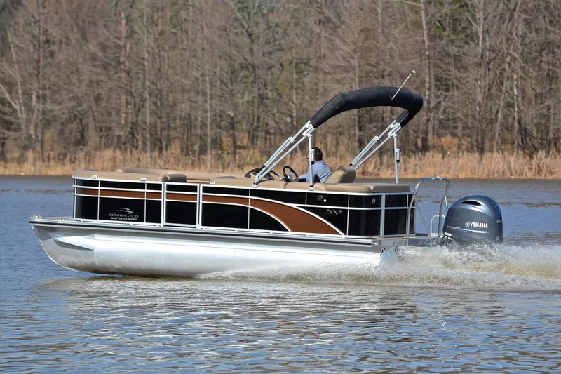 Slide: The Image of 2019 Bennington 21 SSX pontoon boat cruising on a lake with Yamaha outboard motor. - 4