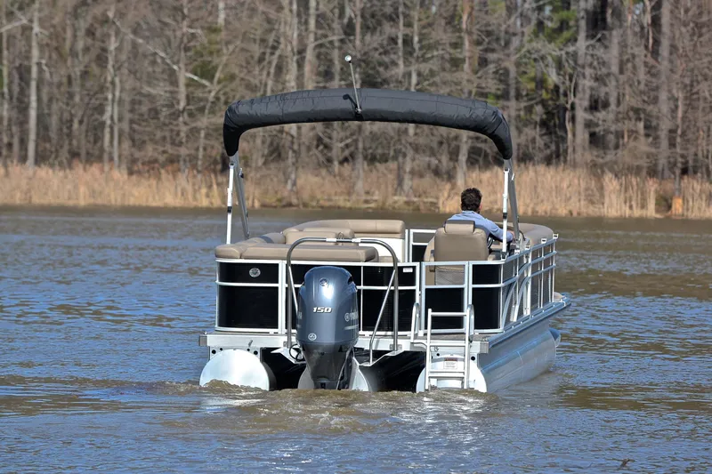 Slide: The Image of 2019 Bennington 21 SSX pontoon boat cruising on a calm lake. - 7