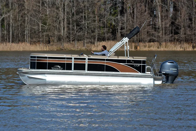 Slide: The Image of 2019 Bennington 21 SSX pontoon boat cruising on a calm lake. - 8