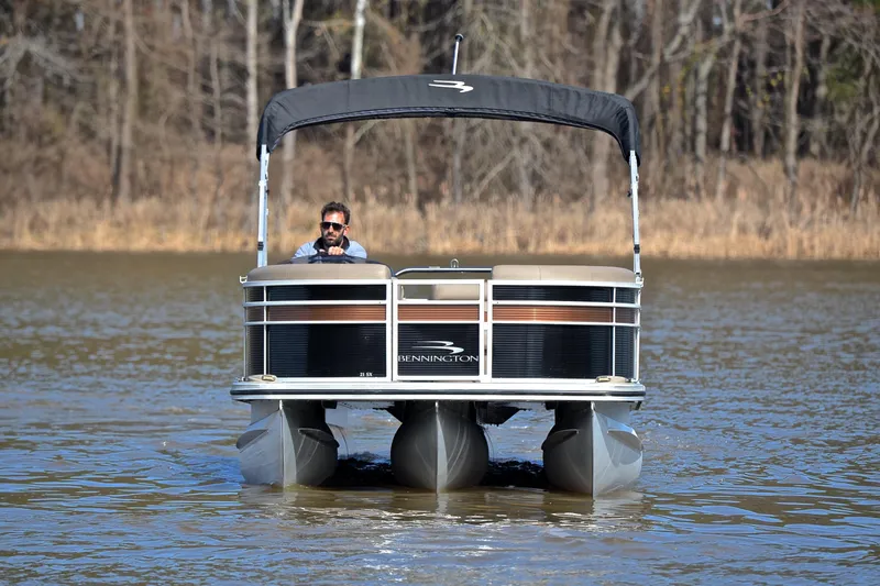 Slide: The Image of 2019 Bennington 21 SSX pontoon boat on a calm lake with trees in the background. - 9