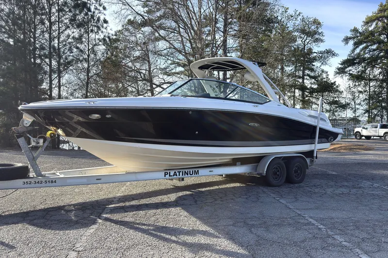 Slide: The Image of 2008 Sea Ray 270 SLX boat on trailer, parked outdoors with trees in background. - 0