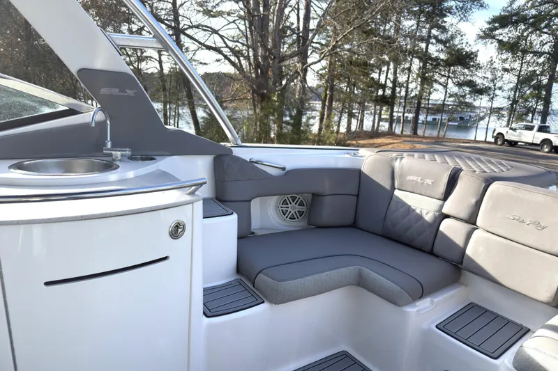Slide: The Image of 2008 Sea Ray 270 SLX boat interior with seating and sink, near a scenic lakeside. - 17
