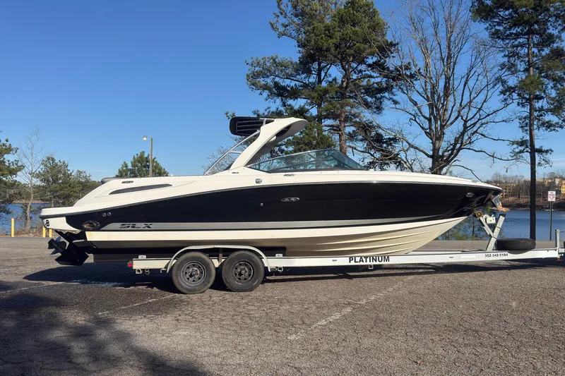 Slide: The Image of 2008 Sea Ray 270 SLX boat on trailer, parked near a lake with trees. - 22