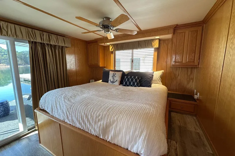 Slide: The Image of Cozy bedroom in 2004 Lakeview 16x68 houseboat with wood paneling and lake view. - 10