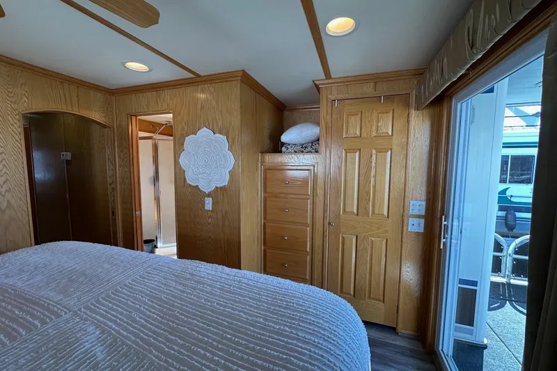 Slide: The Image of Bedroom interior of 2004 Lakeview 16x68 houseboat with wooden cabinetry and sliding glass door. - 11