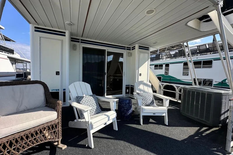Slide: The Image of Outdoor seating area on a 2004 Lakeview 16x68 houseboat with chairs and a wicker sofa. - 14