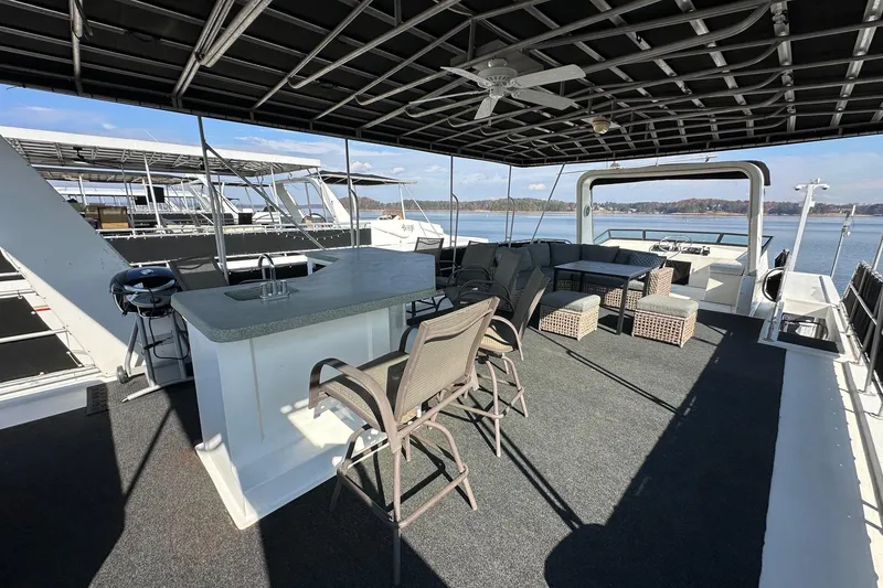 Slide: The Image of Spacious 2004 Lakeview 16x68 houseboat deck with seating, bar, and scenic lake view. - 15