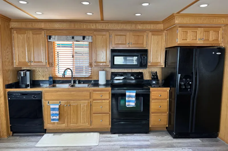 Slide: The Image of Modern kitchen in 2004 Lakeview 16x68 model with wooden cabinets and black appliances. - 4