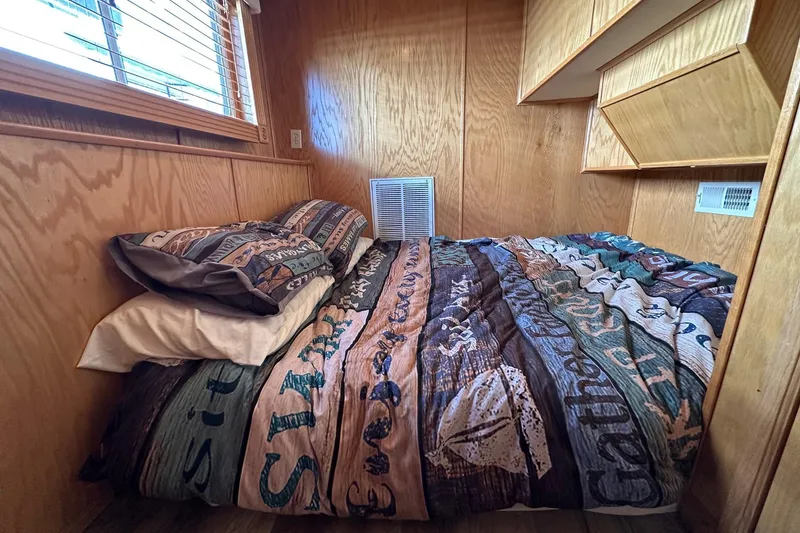 Slide: The Image of Cozy bedroom in 2004 Lakeview 16x68 houseboat with wooden walls and colorful bedding. - 7