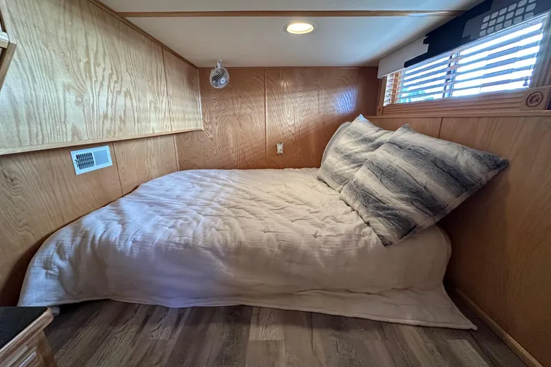 Slide: The Image of Cozy bedroom in 2004 Lakeview 16x68 houseboat with wood paneling and soft bedding. - 8