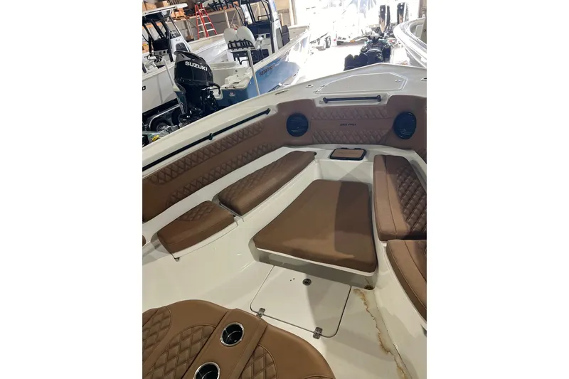 Slide: The Image of 2025 Sea Pro 322 Offshore boat interior with brown cushioned seating and speakers. - 5
