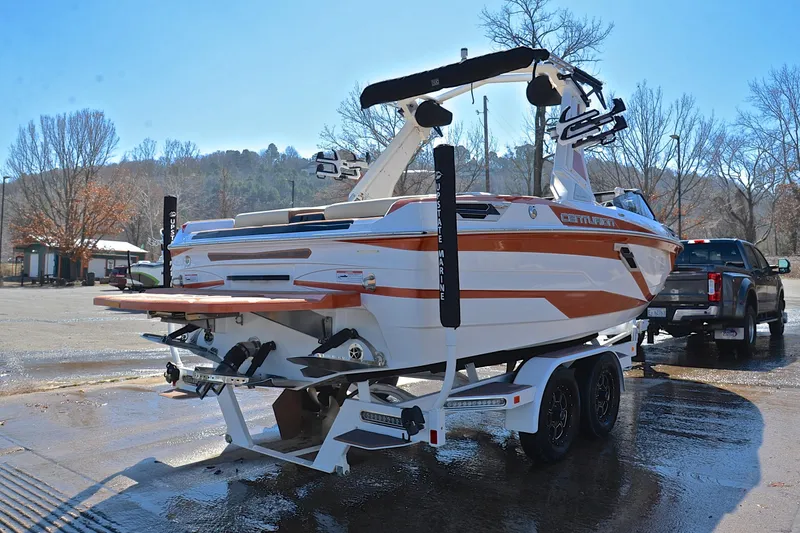 Slide: The Image of 2023 Centurion Ri230 boat on trailer, parked outdoors, with a truck. - 16