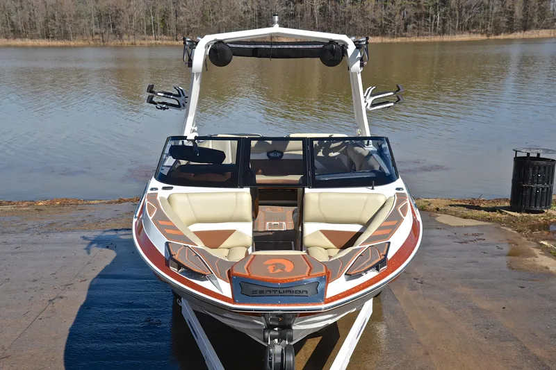 Slide: The Image of 2023 Centurion Ri230 boat at a lakeside launch ramp, showcasing sleek design and seating. - 19