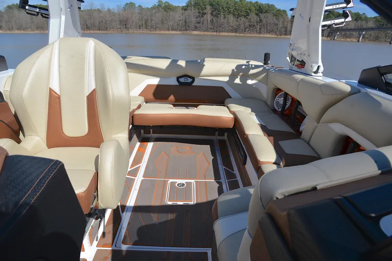 Slide: The Image of 2023 Centurion Ri230 boat interior with luxurious seating and stylish design on a calm lake. - 24