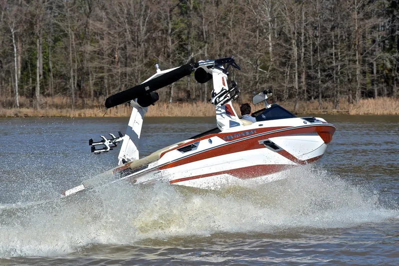 Slide: The Image of 2023 Centurion Ri230 boat cruising on a lake with forested background. - 5