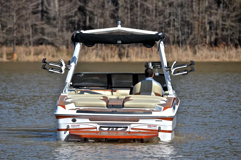 Slide: The Image of 2023 Centurion Ri230 boat on a lake, rear view with wakeboard racks. - 9