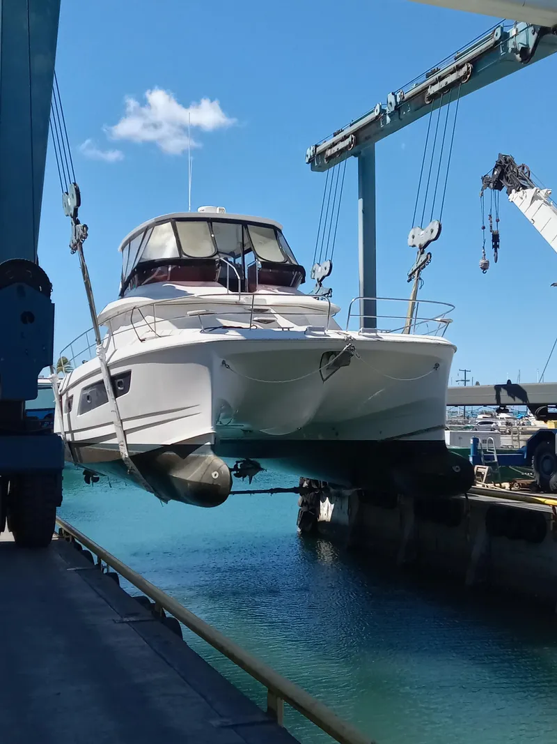 Slide: The Image of 2016 Aquila 44 yacht being lifted by crane at a marina. - 2