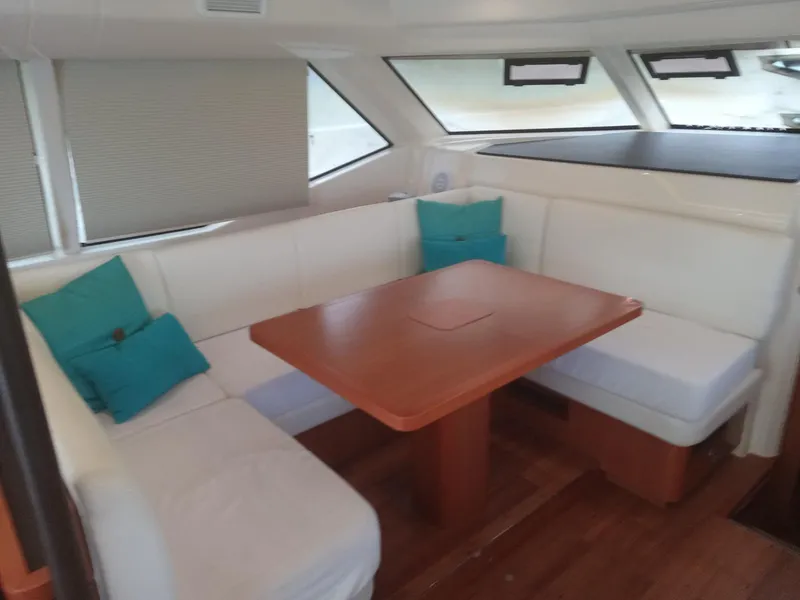 Slide: The Image of Interior of 2016 Aquila 44 yacht with white seating and wooden table. - 24