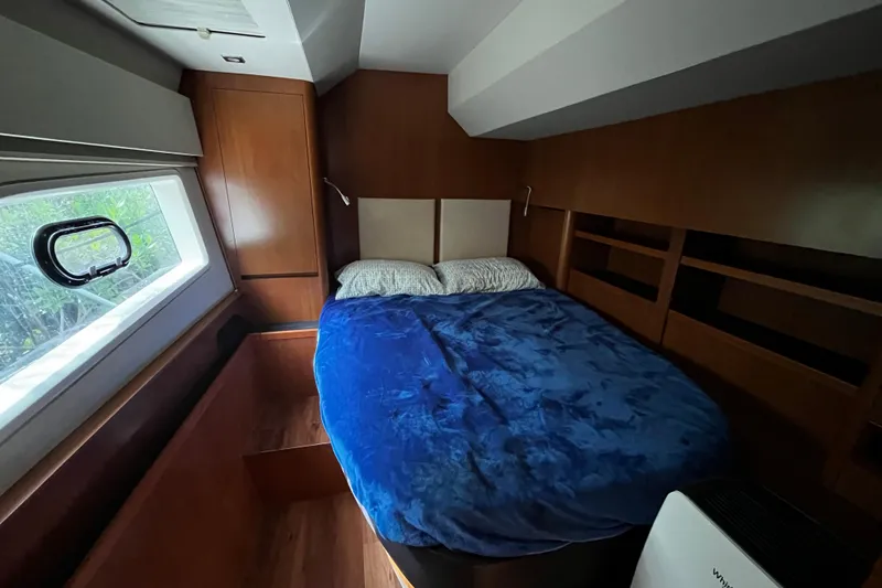 Slide: The Image of Cozy bedroom in 2016 Aquila 44 yacht with blue bedding and wooden interior. - 31