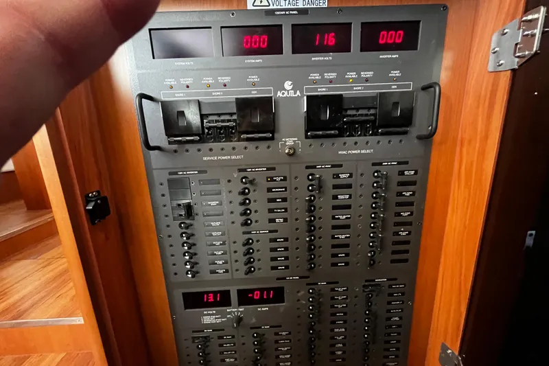 Slide: The Image of Electrical control panel of a 2016 Aquila 44 yacht, displaying voltage and amperage readings. - 34