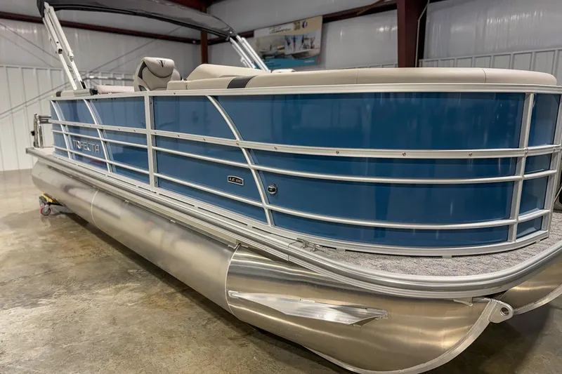 Slide: The Image of 2025 Trifecta 22 RF LE pontoon boat with blue exterior in a showroom. - 3
